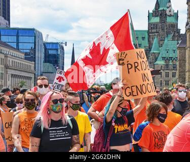 Ottawa, Canada - le 1er juillet 2021 : des milliers de personnes ont défilé lors de la marche de la fête du Canada qui s'est terminée par un rassemblement sur la colline du Parlement. Ils croient qu'il n'est pas approprié de célébrer la fête du Canada à la lumière de la découverte récente de tombes non marquées sur des terrains d'école résidentielle. Banque D'Images