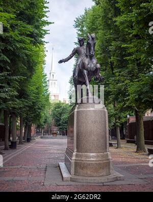 Boston, Massachusetts, États-Unis, 12 juillet 2017 : statue de Paul Revere à cheval avec l'ancienne église du Nord de Boston qui s'élève en arrière-plan. Banque D'Images