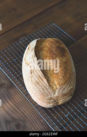 Pain de levain maison artisanal fraîchement cuit sur une table en bois de roche fraîche arrière-plan Banque D'Images