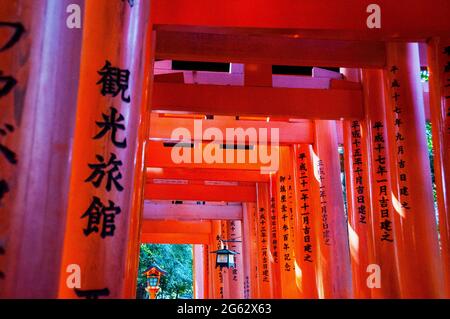 Personnages japonais sur toriis au sanctuaire Fushimi Inari à Kyoto connu sous le nom de Senbon Trail, Japon. Banque D'Images