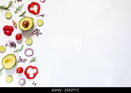 Mise en page créative de tomates, concombres, poivrons, avocats et salades. plat. Concept alimentaire. Place pour votre texte. Banque D'Images