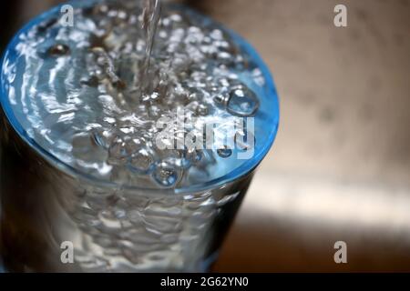 Kaufbeuren, Allemagne. 1er juillet 2021. ILLUSTRATION - l'eau du robinet s'écoule dans un verre placé dans un évier. Credit: Karl-Josef Hildenbrand/dpa/Alay Live News Banque D'Images