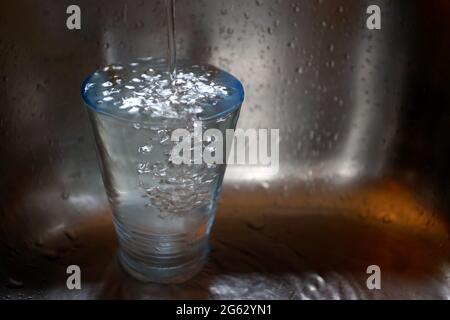 Kaufbeuren, Allemagne. 1er juillet 2021. ILLUSTRATION - l'eau du robinet s'écoule dans un verre placé dans un évier. Credit: Karl-Josef Hildenbrand/dpa/Alay Live News Banque D'Images