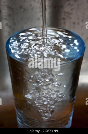 Kaufbeuren, Allemagne. 1er juillet 2021. ILLUSTRATION - l'eau du robinet s'écoule dans un verre placé dans un évier. Credit: Karl-Josef Hildenbrand/dpa/Alay Live News Banque D'Images