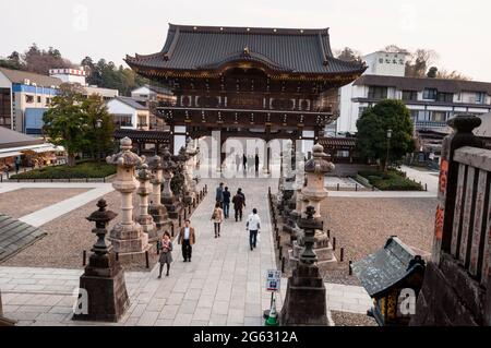 Porte principale du temple Naritasan Sinsho-ji à Narita, Japon avec des lanternes en pierre japonaises bordant le chemin. Banque D'Images