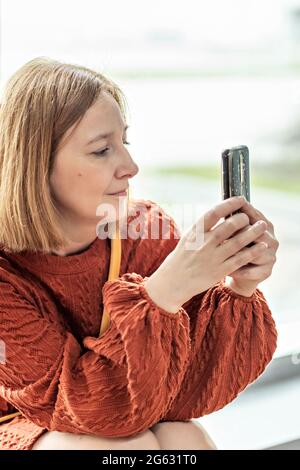 Une jeune femme prend une photo sur un smartphone, prend une vidéo. Banque D'Images