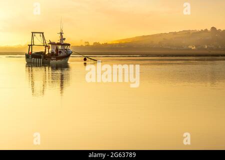 Appledore, North Devon, Angleterre. Vendredi 2 juillet 2021 - les nuages tôt le matin donnent la place à la brume tandis que le soleil commence à se lever derrière le bateau de pêche indépendant 'serene Skye', amarré sur l'estuaire de la rivière Torridge. Le 'Sune Skye' travaille dans les eaux autour de la baie de Bideford et vend ses prises à la communauté locale depuis le quai d'Appledore dans le nord du Devon. Crédit : Terry Mathews/Alay Live News Banque D'Images