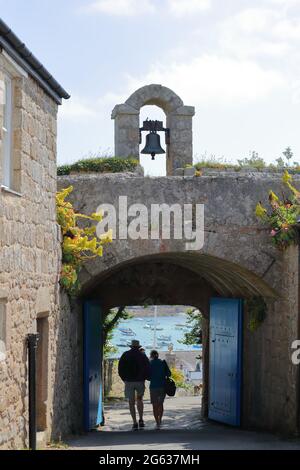Un couple passe la porte principale à travers l'ancien mur du château de la garnison sur St.Mary's, île de Scilly, Cornwall, Royaume-Uni Banque D'Images