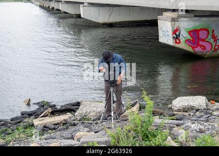 Un photographe de paysage d'ancienne école utilisant un appareil photo grand format Graflex prend des photos à Jamaica Bay à Queens, New York City. Banque D'Images