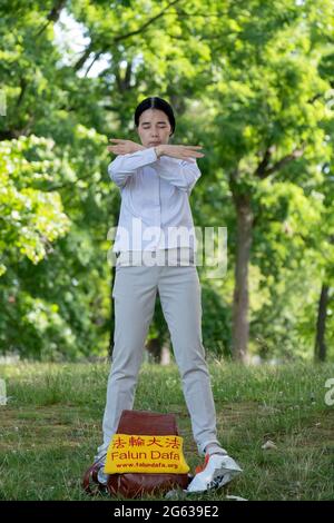 Une femme asiatique américaine fait des exercices de Falun Dong lents dans un parc à Queens, New York. Banque D'Images