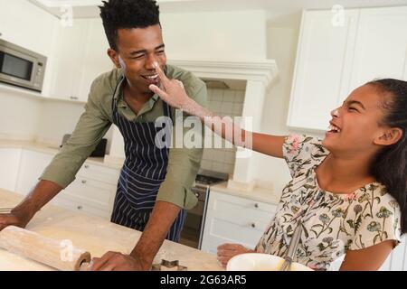 Joyeux père et fille afro-américain ayant plaisir à cuisiner dans la cuisine Banque D'Images