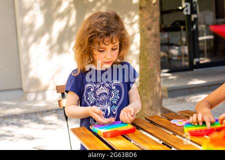 le jouet antistress coloré de violon pousser dans les mains des enfants Banque D'Images