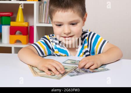 Un enfant de 4 ans apprend à compter de l'argent. Alphabétisation financière et éducation à l'investissement pour les enfants Banque D'Images