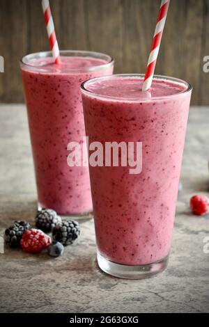 Deux smoothies aux baies mélangées dans de grands verres décoratifs sur la surface en pierre Banque D'Images