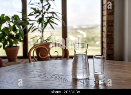 De l'eau dans une verseuse et du verre sur une table en bois dans un style vintage. Restaurant italien de fond pour votre conception. Concept de style de vie du restaurant. Concept alimentaire. Banque D'Images
