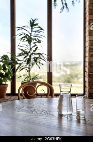 De l'eau dans une verseuse et du verre sur une table en bois dans un style vintage. Restaurant italien de fond pour votre conception. Concept de style de vie du restaurant. Concept alimentaire. Banque D'Images