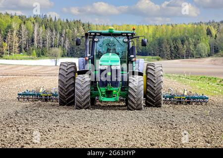 Tracteur John Deere 7230R et herse Multiva Optima T900 en champ, un jour de ressort, vue avant. Salo, Finlande. 16 mai 2021. Banque D'Images
