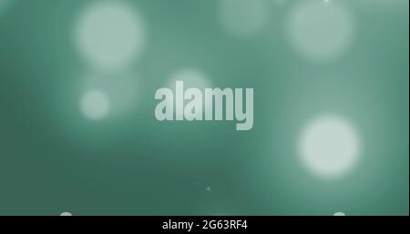 Image de taches blanches brillantes de lumière se déplaçant dans le mouvement hypnotique sur fond vert Banque D'Images