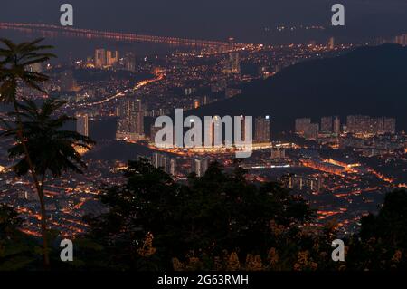 La silhouette de palmiers avec une vue nocturne de la ville de l'air itam sur l'île de Penang Malaysia. Banque D'Images