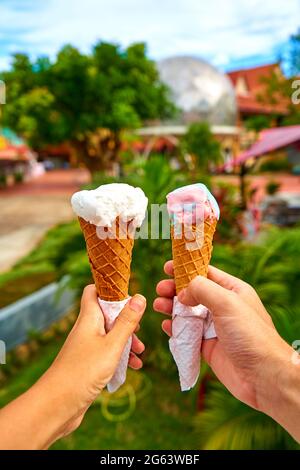 Un couple prend des photos de cônes de crème glacée dans leurs mains. Banque D'Images