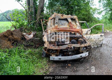 Une voiture brûlée se déversait sur une zone de départ en bordure de route dans une route de campagne. Photo prise Ryedown Lane près de Romsey Hampshire Angleterre. Banque D'Images