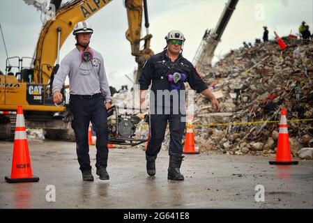 Surfside, Floride, États-Unis. 1er juillet 2021. Les travailleurs de la recherche et du sauvetage urbains de la FEMA portent un générateur au condominium collapsed Champlain Towers South le 1er juillet 2021 à Surfside, en Floride. Credit: Planetpix/Alamy Live News Banque D'Images