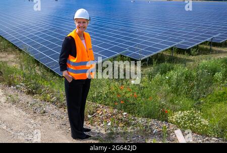 Zietlitz, Allemagne. 02 juillet 2021.: Manuela Schwesig (SPD), le ministre président de Mecklembourg-Poméranie occidentale, se dresse devant une partie de ce qui est, selon l'opérateur, le parc solaire le plus puissant de Mecklembourg-Poméranie occidentale. Près de 200,000 modules solaires ont été installés sur 86 hectares dans une ancienne mine de gravier. Wemag, fournisseur d'énergie basé à Schwerin, est un co-investisseur. Le parc a une production nominale de 80 mégawatts et pourrait produire environ 74,000 mégawatts-heures d'électricité par année, fournissant jusqu'à 18,500 ménages de quatre personnes avec de l'énergie. Crédit : dpa Picture Alliance/al Banque D'Images