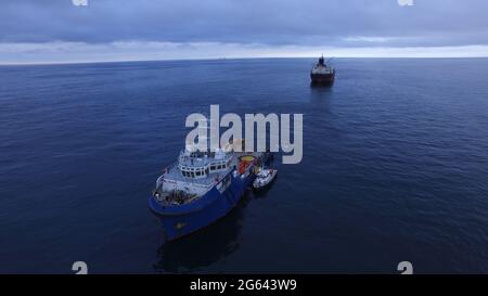 Bateau à remorqueurs bleu avec superstructure blanche en cours, vue latérale. Banque D'Images