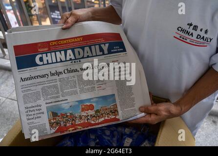 Hong Kong, Chine. 1er juillet 2021. Une femme distribue les journaux China Daily où figurent sur sa couverture le 100e anniversaire de la fondation du Parti communiste chinois à Hong Kong le 1er juillet 2021. (Photo par Miguel Candela/SOPA Images/Sipa USA) crédit: SIPA USA/Alay Live News Banque D'Images