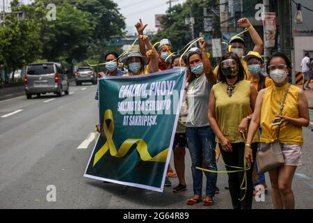 Les supporters portent des signes alors qu'ils se rassemblent à côté du cortège de l'ancien président philippin Benigno Aquino III avant son inhumation à Quezon City, aux Philippines. Banque D'Images