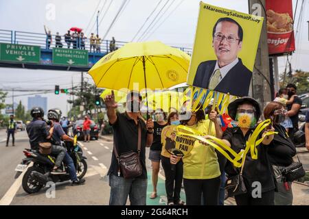 Les supporters portent des signes alors qu'ils se rassemblent à côté du cortège de l'ancien président philippin Benigno Aquino III avant son inhumation à Quezon City, aux Philippines. Banque D'Images