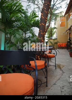 Un calme, caché loin, charmant petit café extérieur, coin repas avec palmiers et lumières scintillantes, pour un emplacement romantique et isolé. Banque D'Images
