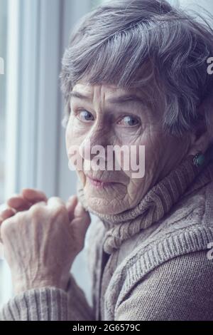 Vieille dame aux cheveux gris et une expression paisible sur son visage. Banque D'Images