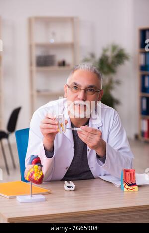 Ancien professeur de dentiste assis dans la salle de classe Banque D'Images
