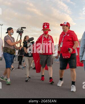 Les fans de football suisse vêtus de tenues rouges colorées de Suisse, masque de visage, sont interviewés après le match de quart-finale de l'UEFA EURO 2020, à Saint-Pétersbourg, en Russie Banque D'Images