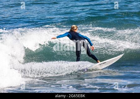 Jeune garçon australien adolescent en combinaison surfant sur une vague à Avalon Beach à Sydney, Nouvelle-Galles du Sud, Australie Banque D'Images