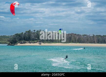 Les kiteboardeurs sont tirés sur l'eau par des cerfs-volants à Sandy Cove, dans l'estuaire de la rivière Noosa, à Noosa Heads, Sunshine Coast, Queensland, Australie Banque D'Images