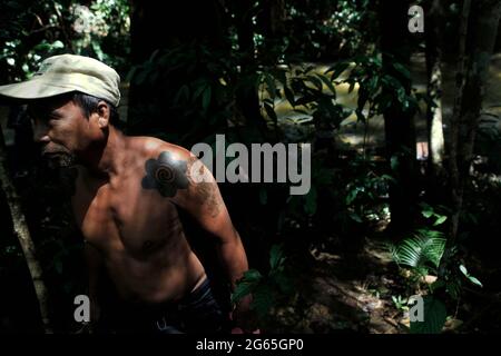 Simon Salem marchant sur le bord de la rivière. Il est membre de la communauté traditionnelle Dayak IBAN à Sungai Utik, Kalimantan occidental, Indonésie. Banque D'Images