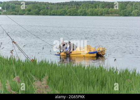 BÉLARUS, MINSK - 28 MAI 2021 : des hommes sur un catamaran réparent une corde d'ancrage. Photos. Banque D'Images