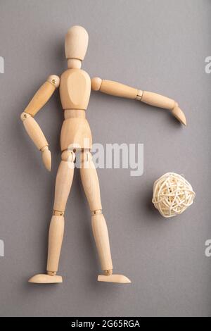 Mannequin en bois jouant au football sur fond gris pastel. Espace de copie, isolé, concept sportif. Banque D'Images