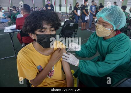 3 juillet 2021, Denpasar, Bali, Indonésie : un jeune homme injecté par une dose de vaccin. L'armée régionale de Bali de Kodam IX Udayana tiendra une vaccination de masse Covid-19 contre les jeunes de moins de 12-15 ans au cours du premier jour de la mise en œuvre de Java et Bali Emergency Community Activities restriction (PPKM). Le gouvernement central de l'Indonésie imposera le PPPKM Emergeny du 3 au 20 juillet 2021 pour diminuer les dernières surtensions du massif Covid-19. (Image de crédit : © Dicky Bisinglasi/ZUMA Wire) Banque D'Images