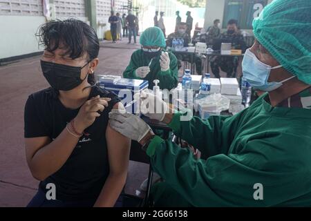 Denpasar, Bali, Indonésie. 3 juillet 2021. Une jeune femme injectée par une dose de vaccin. L'armée régionale de Bali de Kodam IX Udayana tiendra une vaccination de masse Covid-19 contre les jeunes de moins de 12-15 ans au cours du premier jour de la mise en œuvre de Java et Bali Emergency Community Activities restriction (PPKM). Le gouvernement central de l'Indonésie imposera le PPPKM Emergeny du 3 au 20 juillet 2021 pour diminuer les dernières surtensions du massif Covid-19. Credit: Dicky Bisinglasi/ZUMA Wire/Alay Live News Banque D'Images