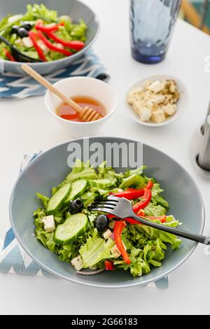 Assiettes avec salade grecque fraîche sur table légère Banque D'Images