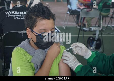 Denpasar, Bali, Indonésie. 3 juillet 2021. Un jeune homme injecté par une dose de vaccin. L'armée régionale de Bali de Kodam IX Udayana tiendra une vaccination de masse Covid-19 contre les jeunes de moins de 12-15 ans au cours du premier jour de la mise en œuvre de Java et Bali Emergency Community Activities restriction (PPKM). Le gouvernement central de l'Indonésie imposera le PPPKM Emergeny du 3 au 20 juillet 2021 pour diminuer les dernières surtensions du massif Covid-19. Credit: Dicky Bisinglasi/ZUMA Wire/Alay Live News Banque D'Images