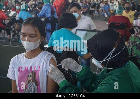 Denpasar, Bali, Indonésie. 3 juillet 2021. Une jeune femme injectée par une dose de vaccin. L'armée régionale de Bali de Kodam IX Udayana tiendra une vaccination de masse Covid-19 contre les jeunes de moins de 12-15 ans au cours du premier jour de la mise en œuvre de Java et Bali Emergency Community Activities restriction (PPKM). Le gouvernement central de l'Indonésie imposera le PPPKM Emergeny du 3 au 20 juillet 2021 pour diminuer les dernières surtensions du massif Covid-19. Credit: Dicky Bisinglasi/ZUMA Wire/Alay Live News Banque D'Images