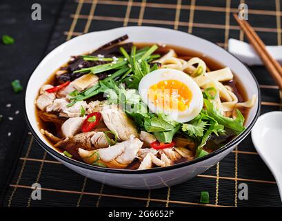 Soupe miso. Soupe japonaise de ramen avec poulet, œuf, nori et nipposinica sur fond sombre. Banque D'Images