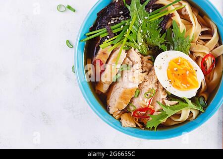 Soupe miso. Soupe japonaise de ramen avec poulet, œuf, nori et nipposinica sur fond clair. Vue de dessus, plan d'appartement Banque D'Images
