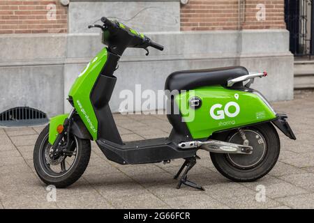 Breda, pays-Bas 28 juin 2021. Scooter électrique vert stationné sur un trottoir dans la ville, attendant d'être loué et utilisé par une application. Partage Banque D'Images