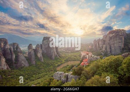 Coucher de soleil sur le monastère Agias Varvaras Roussanou sur le rocher Meteora, Grèce. Ciel de coucher de soleil avec nuages et Meteora Banque D'Images