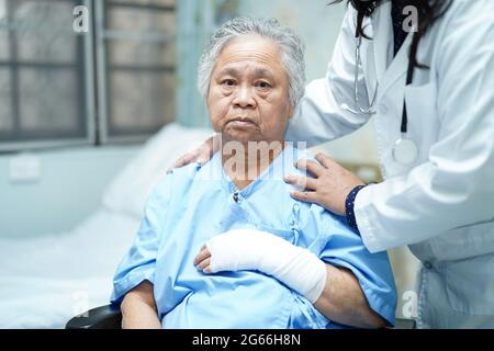 Asiatique senior ou âgée femme âgée patient accident au bras avec bandage sur le lit dans la salle d'hôpital de soins infirmiers : concept médical sain et fort. Banque D'Images